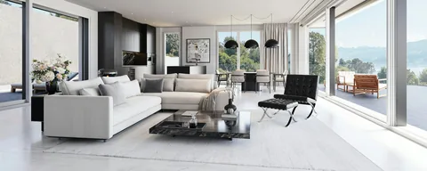 Sala ampla de casa de alto padrão com sofá branco e janelas para a natureza